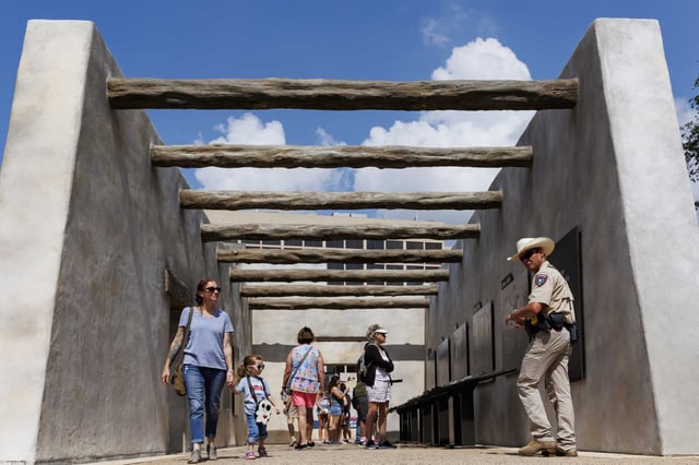 Visitors walk through the Mission Gate and Lunette exhibit at Alamo Plaza during Memorial Day weekend in 2023.  