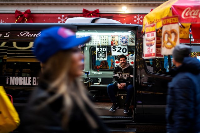 An independent barber waits for customers on his van in a local street in New York, U.S., December 25, 2023. REUTERS/Eduardo Munoz/File photo