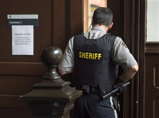A sheriff's deputy stands outside youth court in Halifax on Thursday, Nov. 13, 2014. THE CANADIAN PRESS/Andrew Vaughan
