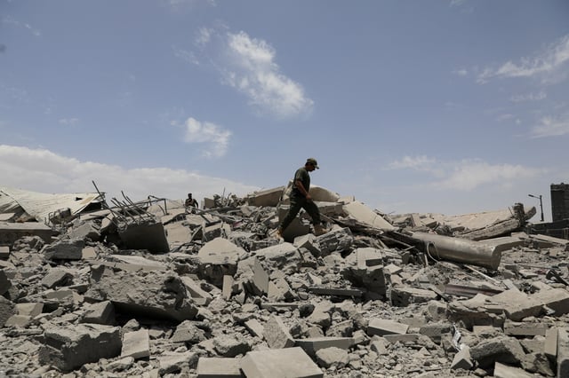A police trooper walks on the rubble of a building destroyed by U.S. air strikes in Sanaa, Yemen April 27, 2025. REUTERS/Khaled Abdullah/File Photo