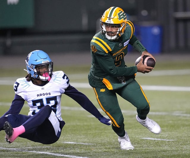 Edmonton Elks quarterback Tre Ford evades a tackle from Toronto Argonauts' Kenneth George Jr. during first half CFL action in Edmonton, on Friday October 25, 2024. THE CANADIAN PRESS/Larry Wong