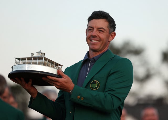 Northern Ireland's Rory McIlroy celebrates with his green jacket and the trophy after winning The Masters and completing a career grand slam. Augusta National Golf Club, Augusta, Georgia, U.S., April 13, 2025 REUTERS/Pilar Olivares/File Photo