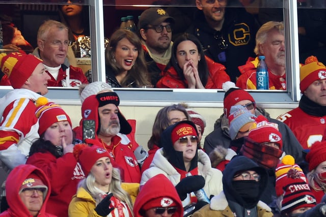 Singer-songwriter Taylor Swift (L) talks with Caitlin Clark (R) of the Indiana Fever during the second half in the AFC Divisional Playoff between the Houston Texans and the Kansas City Chiefs at GEHA Field at Arrowhead Stadium on January 18, 2025 in Kansas City, Missouri.