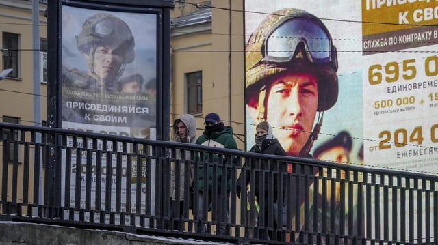 Menschen hinter einem Geländer vor Werbung für die russische Armee (Archiv)