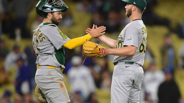 May 13, 2025; Los Angeles, California, USA; Athletics catcher Shea Langeliers (23) and pitcher Justin Sterner (60) celebrate the victory against the Los Angeles Dodgers at Dodger Stadium. Mandatory Credit: Gary A. Vasquez-Imagn Images