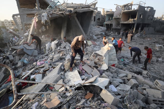 Palestinians inspect the site of an Israeli strike on a house, in Jabalia, in the northern Gaza Strip, May 14, 2025. REUTERS/Mahmoud Issa