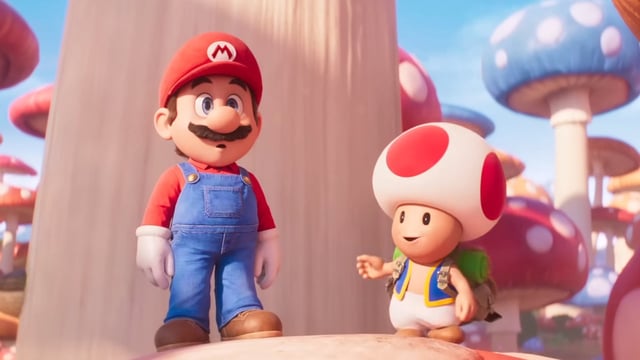 A stunned Mario and a smiling Toad stand in the middle of a mushroom forest in The Super Mario Bros. Movie