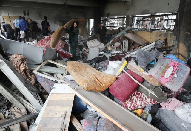 Des Palestiniens inspectent les dégâts dans une école abritant des personnes déplacées à la suite d’une frappe israélienne, à Jabalia dans le nord de la bande de Gaza, le 12 mai 2025.