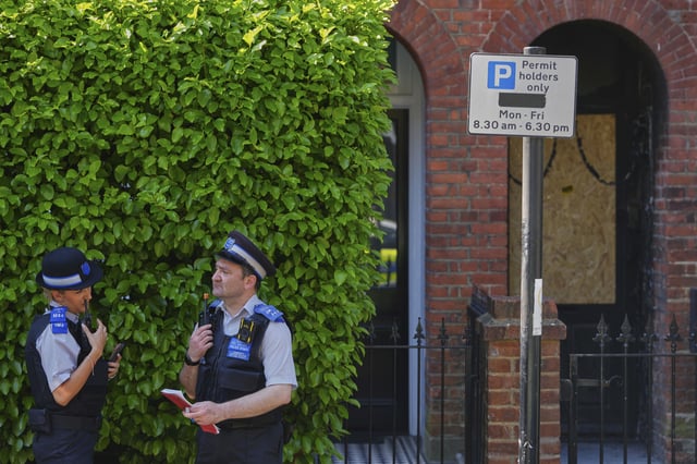 Police Community Support Officers stand near the fire damaged doorway of a house belonging to British Prime Minister Keir Starmer in Kentish Town in London, Tuesday, May 13, 2025. (AP Photo/Kirsty Wigglesworth)