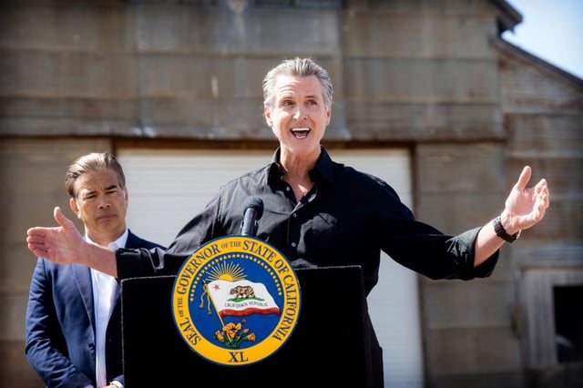 California Gov. Gavin Newsom discusses President Donald Trump’s tariffs, as California Attorney General Rob Bonta, left, listens, during a press conference on Wednesday, April 16, 2025, at an almond farm in Ceres, Calif. (AP Photo/Noah Berger)