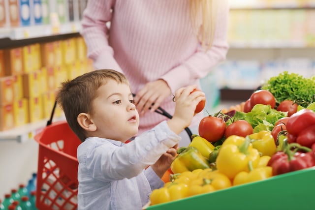 Stock image/file photo: A child handles a vegetable in a grocery store.