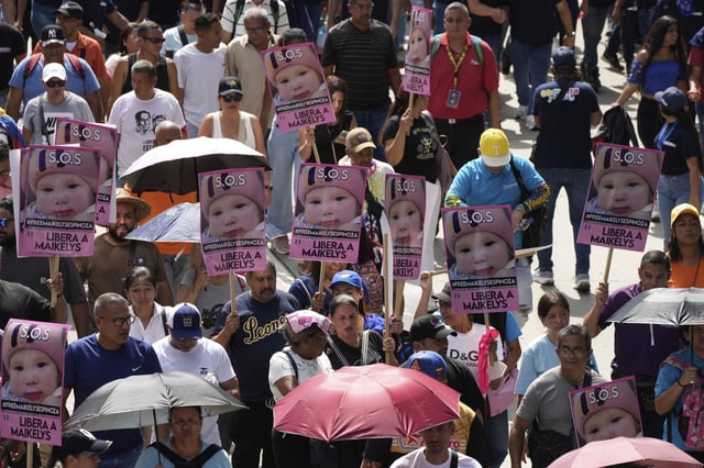 Pro-government supporters hold up signs with the image of Maikelys Espinoza, a 2-year-old in US custody whose parents were deported separately, at a rally in Caracas, Venezuela, Thursday, May 1, 2025. (AP Photo/Ariana Cubillos)