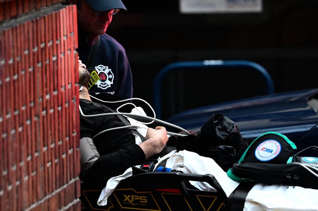 A member of the Portland Fire and Rescue Community Health Assess &amp; Treat (CHAT) team pushes a patient into an ambulance for medical care after they were administered Narcan brand Naloxone nasal spray for a suspected fentanyl drug overdose in Portland, Oregon on January 25, 2024.