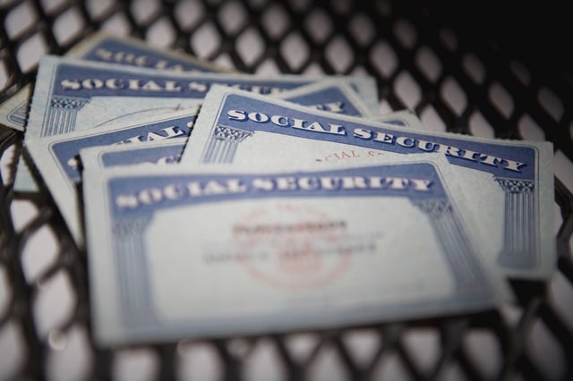 a close up shot of several Social Security cards on a chequered mat.
