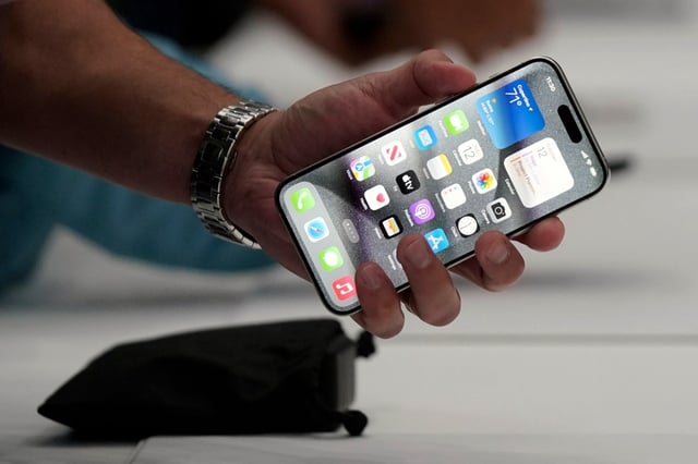 FILE – A person holds an iPhone 15 Pro at the Apple campus, Sept. 12, 2023, in Cupertino, Calif. (AP Photo/Jeff Chiu, File)
