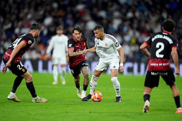 Kylian Mbappe trata de marcharse de tres rivales en el partido entre el Real Madrid y el Mallorca