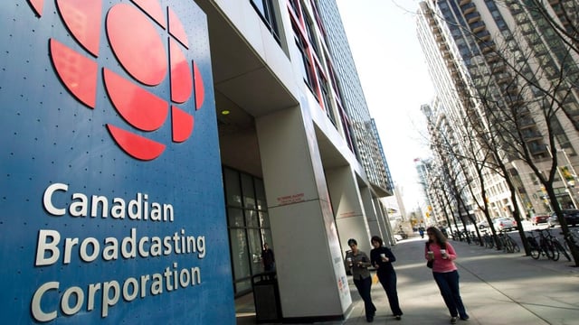 People walk by the CBC building in Toronto on April 4, 2012. The public broadcaster is ending the controversial policy of 'performance pay' for its managers and executives. 