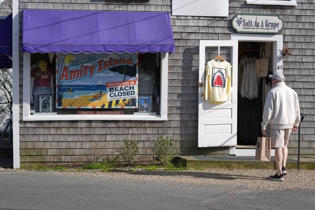 A visitor arrives at a shop selling Jaws-related souvenirs, Wednesday, May 14, 2025, in Edgartown, Mass. (AP Photo/Robert F. Bukaty)