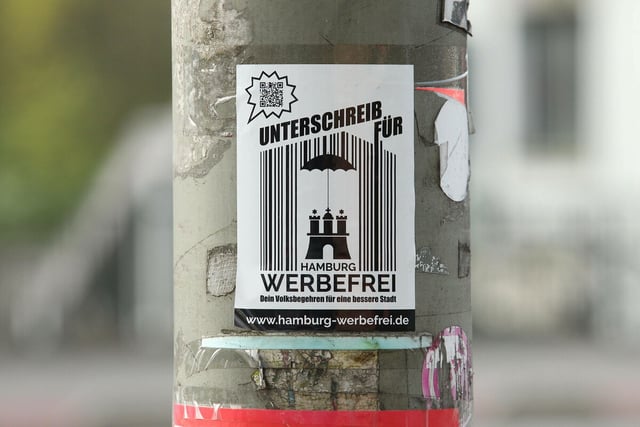 Sticker der Volksinitiative "Hamburg werbefrei" an einem Laternenmasten