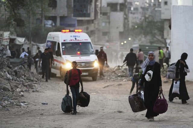Palestinians evacuate after the Israeli army issued an evacuation warning for several schools and a hospital in Gaza City's Rimal neighborhood, Wednesday, May 14, 2025. (AP Photo/Jehad Alshrafi)