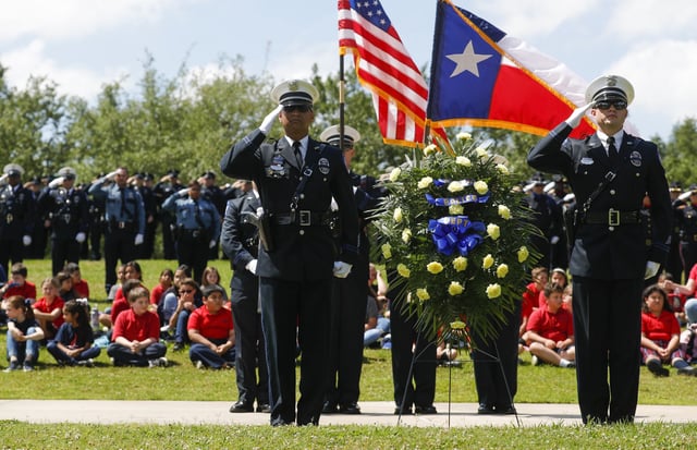 Police officers and other law enforcement salute as Taps is played during the annual police memorial in honor of Sgt. Ed Holcomb, Jr. at Heritage Park, Thursday, May 13, 2021, in Conroe.