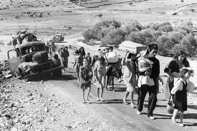 FILE - Palestinian villagers flee during fighting between Israeli and Arab troops on Nov. 4, 1948. (AP Photo/Jim Pringle, File)