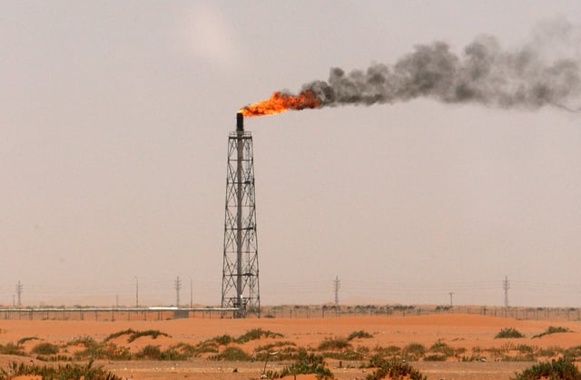A gas flame is seen in the desert near the Khurais oilfield, about 160 km (99 miles) from Riyadh, June 23, 2008. REUTERS/Ali Jarekji/File Photo