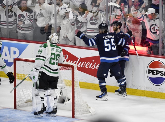Winnipeg Jets' Mark Scheifele (55) celebrates his goal against Dallas Stars goaltender Jake Oettinger (29) with Kyle Connor (81) during second period NHL playoff hockey action in Winnipeg, Thursday, May 15, 2025. THE CANADIAN PRESS/Fred Greenslade