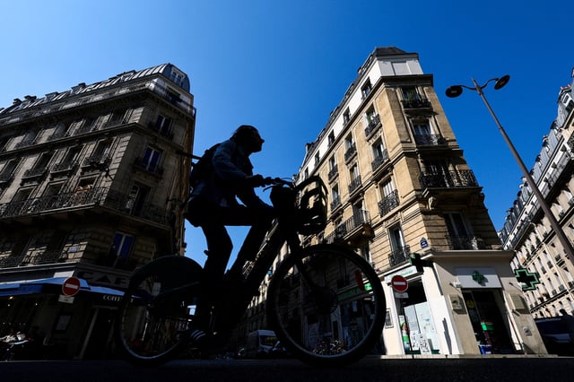 A man rides his bicycle on Rue Pache street, near the location where a masked gang attempted to kidnap the daughter of a crypto businessman, in Paris, France, May 14, 2025. REUTERS/Gonzalo Fuentes/File Photo