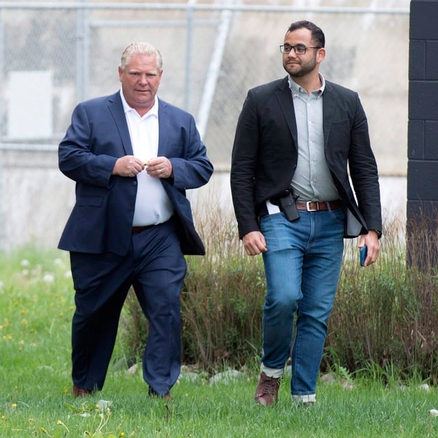 Ontario PC Leader Doug Ford and his then-deputy chief of staff Amin Massoudi, right, return from a private chat following a campaign event in Sault Ste. Marie, Ont., on June 1, 2018. THE CANADIAN PRESS/Frank Gunn
