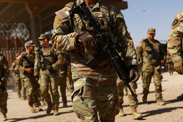 National Guard soldiers walk on the day U.S. authorities hold a ceremony to deputise the Texas National Guard to enforce Title 8 immigration laws, near the U.S.-Mexico border in El Paso, Texas, U.S. February 27, 2025.