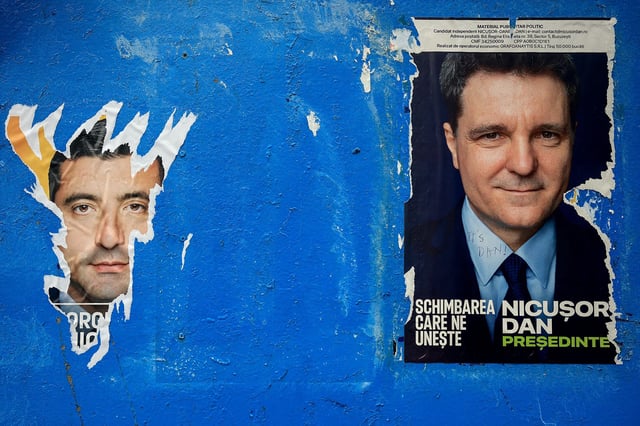 A torn out poster featuring presidential candidate George Simion is seen next to one of Nicusor Dan, with the writing "Its Dan", ahead of the second round of the presidential elections, in Bucharest, Romania, May 16, 2025. REUTERS/Louisa Gouliamaki