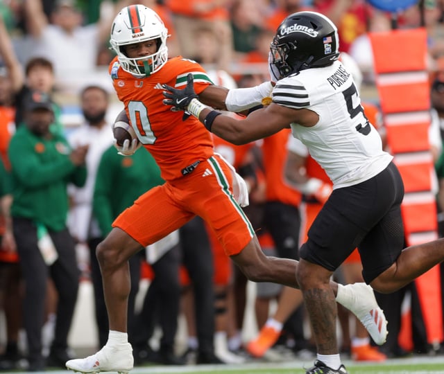 Miami (Fla.) wide receiver Joshisa Trader (0) holds off Iowa State defensive back Myles Purchase during the 2024 Pop-Tarts Bowl at Camping World Stadium.