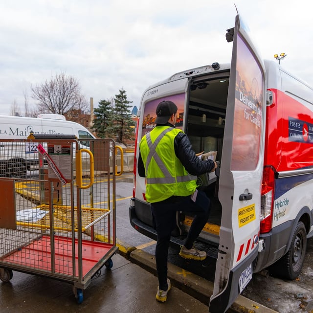 A Canada Post worker fills his truck with mail in Montreal on Tuesday, Dec.17, 2024.