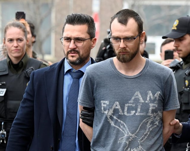 Steeve Gagnon is escorted by police out of court in Amqui, Que., Tuesday, March 14, 2023. Gagnon is facing charges relating to an incident where a driver of a pickup truck drove into pedestrians, killing two people and injuring nine. THE CANADIAN PRESS/Jacques Boissinot