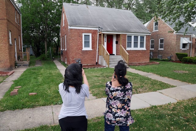 Letty Matias, left, of Hammond, Indiana, and her sister, Jenny Matias, of Whiting, Indiana, take photos of the childhood home of Pope Leo XIV in Dolton May 16, 2025. “We already love Pope Leo,” Letty Matias said. (Terrence Antonio James/Chicago Tribune)