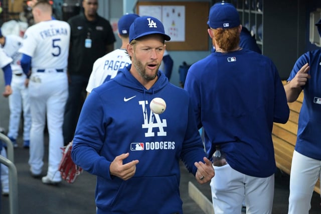 Dodgers’ Clayton Kershaw tosses a ball as he walks through the dugout early in a baseball game against the Oakland Athletics, Wednesday, May 14, 2025, in Los Angeles. (AP Photo/Jayne Kamin-Oncea)
