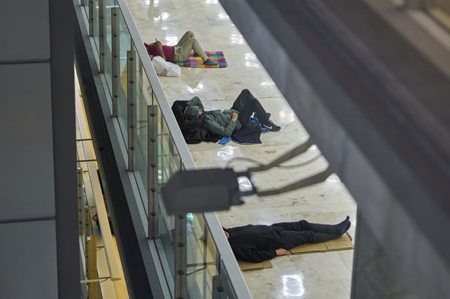 People sleep on the floor of Terminal 4 at Adolfo Suarez-Madrid Barajas Airport in Madrid, Spain, Thursday, May 15, 2025. (AP Photo/Manu Fernandez)