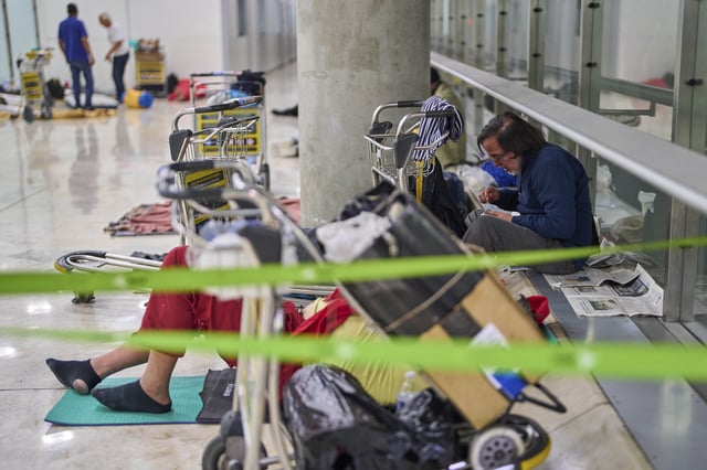 A person eats sitting on the floor of Terminal 4 at Adolfo Suarez-Madrid Barajas Airport in Madrid, Spain, Thursday, May 15, 2025. (AP Photo/Manu Fernandez)