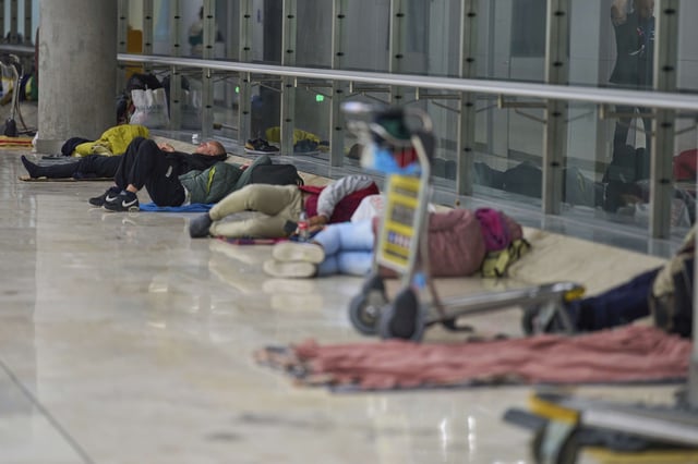 People sleep on the floor of Terminal 4 at Adolfo Suarez-Madrid Barajas Airport in Madrid, Spain, Thursday, May 15, 2025. (AP Photo/Manu Fernandez)