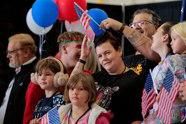 Newly arrived South Africans wait to hear welcome statements from U.S. government officials in a hangar at Atlantic Aviation Dulles near Washington Dulles International Airport on May 12, 2025 in Dulles, Virginia.