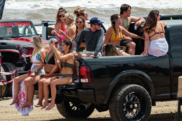 Partygoers enjoy a ride in a pickup during Jeep Weekend in 2020.