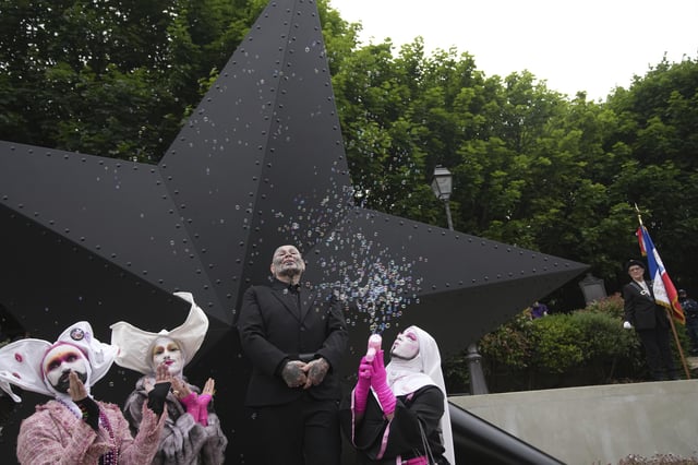 French artist Jean-Luc Verna, center, poses with performers during the inauguration of his sculpture, a memorial to the long-ignored gay victims of the Nazi regime and to all LGBTQ+ people persecuted throughout history, in Paris, Saturday, May 17, 2025. (AP Photo/Christophe Ena)