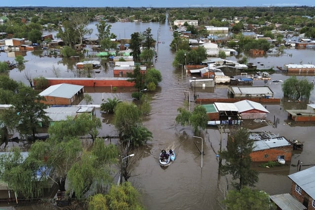 Boats move through flooded streets after heavy rains in Campana, Argentina, Saturday, May 17, 2025. (AP Photo/Rodrigo Abd)