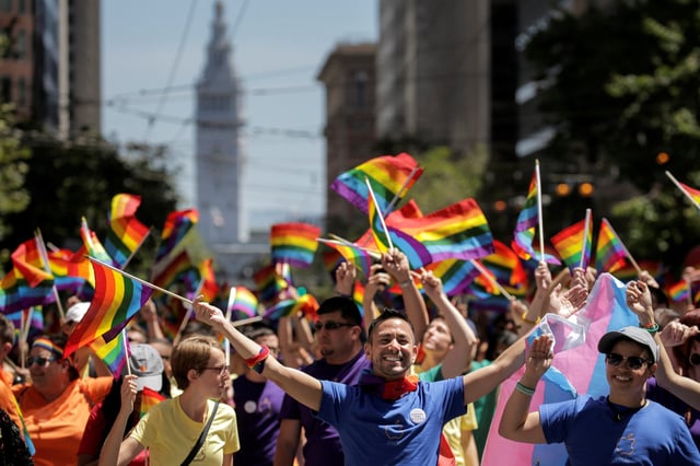 Apple employees wave rainbow flags while marching in the San Francisco LGBT Pride Parade in San Francisco, California, U.S. June 26, 2016.