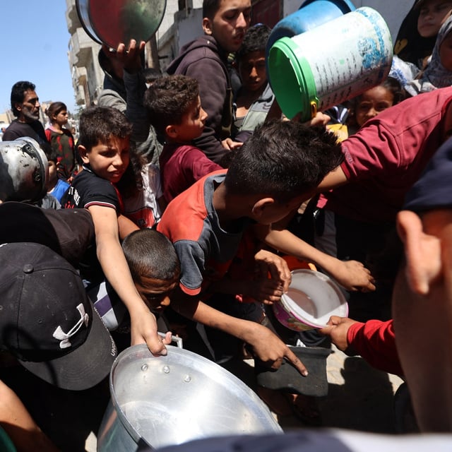 Palestinians queue to receive a food portion from a charity kitchen in the Bureij refugee camp in the central Gaza Strip on April 29, 2025. (Photo by Eyad BABA / AFP) (Photo by EYAD BABA/AFP via Getty Images)