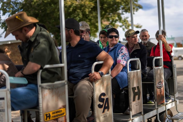 Visitors at the Nampo agricultural fair, one of the largest in the southern hemisphere, ride past the wall of remembrance, a tribute to farmers killed since 1961, near Bothaville, South Africa, May 15, 2025. (AP Photo/Jerome Delay)