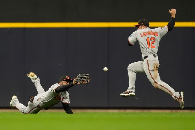 Baltimore Orioles&#39; Cedric Mullins, left, and Ramón Laureano (12) are unable to catch a fly ball during the fifth inning of a baseball game against the Milwaukee Brewers, Monday, May 19, 2025, in Milwaukee. (AP Photo/Aaron Gash)