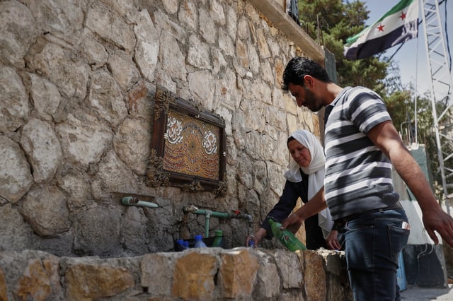 Visitors fill bottles with water from the spring in Ein el-Fijeh, Barada Valley, Syria, Thursday, May 8, 2025. The Ein el-Fijeh spring, the main source of water for Damascus, is almost dry and many people in the capital and its suburbs are now relying on buying water from tanker trucks that fill from wells. (AP Photo/Omar Sanadiki)
