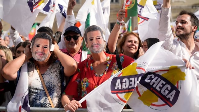 Supporters of the populist right-wing party Chega wear masks of its leader, Andre Ventura, during an election campaign rally in downtown Lisbon on May 16, 2025, ahead of the May 18 general election. 